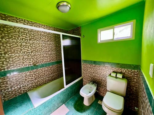 a bathroom with a toilet a sink and a window at Cabañas Luces De La Selva in Puerto Iguazú