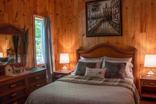 a bedroom with a bed and two lamps and a mirror at Chalet L'Envolée near Tremblant in Saint-Faustin