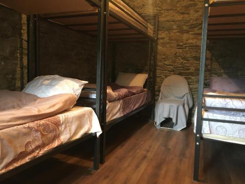 a room with three bunk beds and a wooden floor at Qaldea Resort in Ushguli