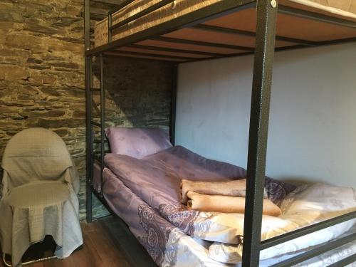 a bedroom with two bunk beds and a chair at Qaldea Resort in Ushguli
