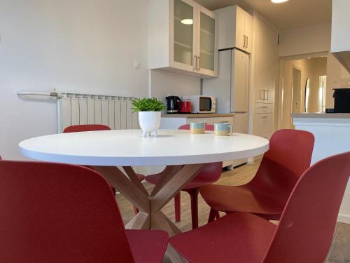 a white table and red chairs in a kitchen at Dashing Central Oasis in Zadar