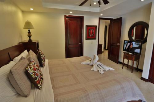 a bedroom with a large bed with towels on it at Monte Carlo Luxury Condominiums in Jacó