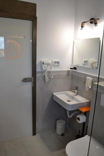 a bathroom with a sink and a mirror and a toilet at ANTICA RESIDENZA TOSCANA in Dumbrăviţa