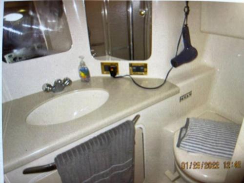 a bathroom with a sink and a mirror and a toilet at Delightful 2 Bdrm Sport Yacht with Pool in Pompano Beach