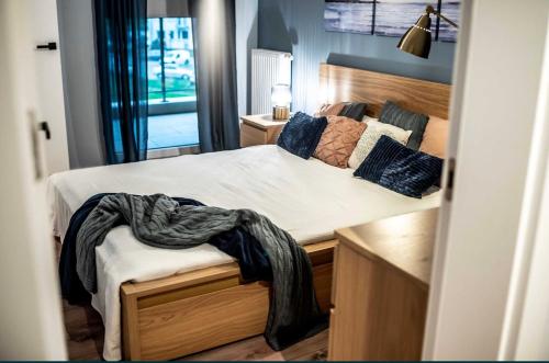 a bedroom with a bed with a blanket on it at Apartamenty Złota 15-Kadzielnia View in Kielce