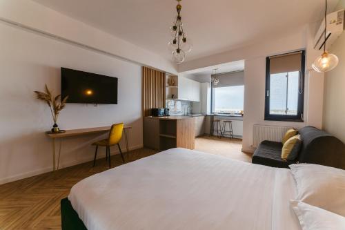 a bedroom with a bed and a desk and a kitchen at SOLMAR Studio Sea View in Năvodari