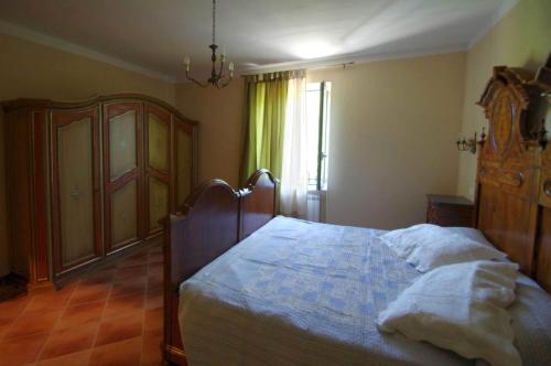 ein Schlafzimmer mit einem großen Bett und einem Fenster in der Unterkunft Agriturismo Mulino del Castello Nasino in Nasino