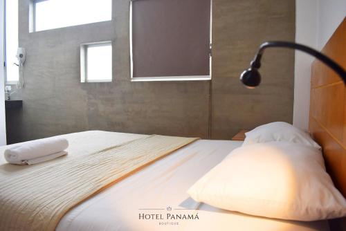 a bed with two pillows and a lamp on it at HOTEL BOUTIQUE PANAMÁ in Guayaquil