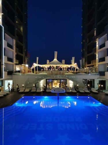 Una gran piscina frente a un edificio por la noche. en SOLMAR Studio Sea View, en Năvodari