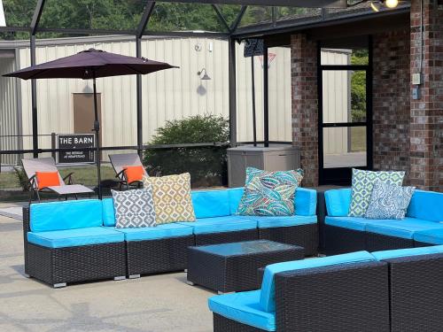 a blue couch with pillows and an umbrella on a patio at The Retreat at Hempstead in Hempstead