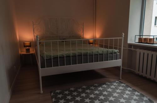 a bedroom with a white bunk bed with two lamps at Rīgas ielas apartamenti 1 in Valmiera