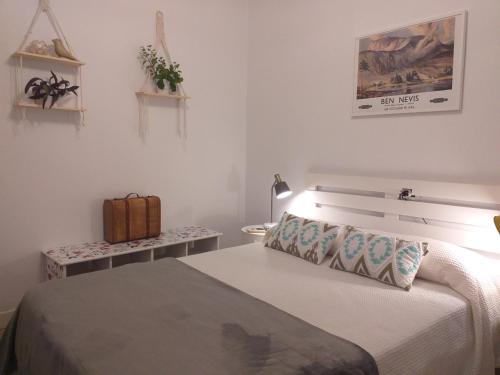 1 dormitorio con 1 cama y 1 maleta en una mesa en Casa Jardín, en Monforte de Lemos