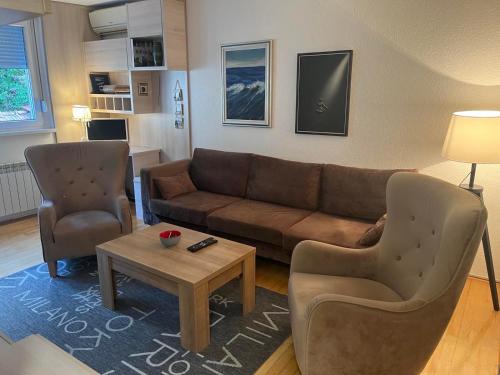 sala de estar con sofá, 2 sillas y mesa en Apartman Uma en Sarajevo
