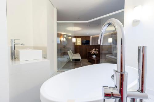 La salle de bains est pourvue d'un lavabo blanc et d'un miroir. dans l'établissement Hotel Cassino Tower São José do Rio Preto by Nacional Inn, à Sao Jose do Rio Preto