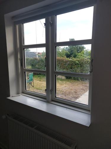 an open window with a view of a yard at Stuelejlighed med have og overdækket terrasse in Odense