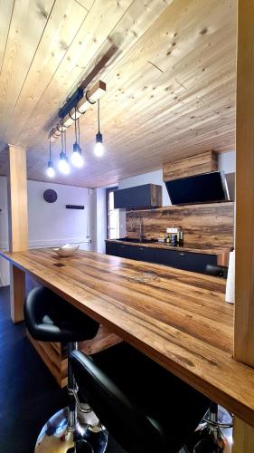 a large wooden table in a room with a kitchen at Charmante maison de Bourg, dans les hauteurs Auvergnate ! in Nonette