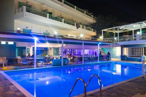 a swimming pool at night with a hotel at Tropicana Inn in Nydri