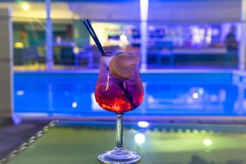 a drink in a glass sitting on top of a table at Tropicana Inn in Nydri