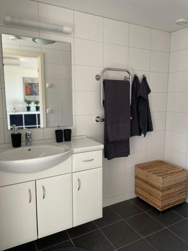 a white bathroom with a sink and a mirror at Ingridgården in Båstad