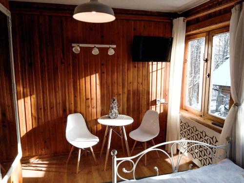 a room with a table and chairs and a tv at Willa Kasprusie in Zakopane