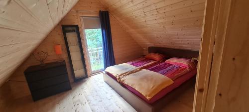 a bedroom with a bed in a wooden cabin at Sunset House in Sulęczyno