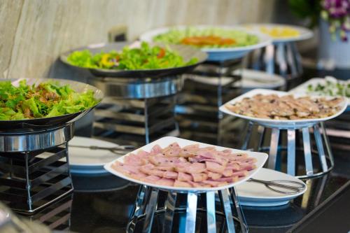 ein Buffet mit Tellern voller Essen auf einem Tisch in der Unterkunft Diamond Luxury Hotel in Hạ Long