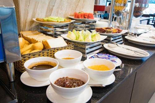 ein Buffet mit Schüsseln und Tellern voller Essen in der Unterkunft Diamond Luxury Hotel in Hạ Long