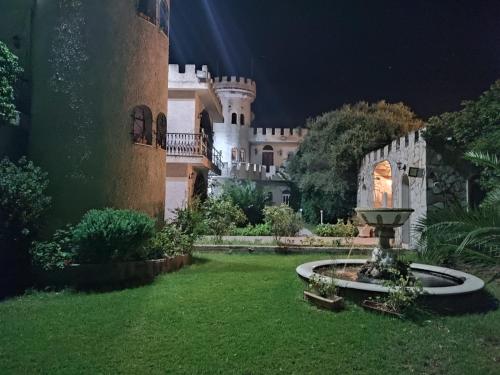 a castle at night with a fountain in the yard at Castle By The Sea in Artemida