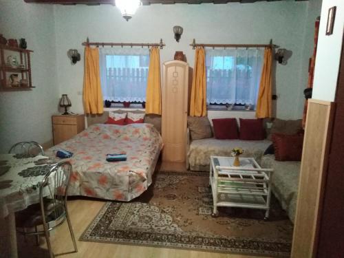 1 dormitorio con 1 cama y 1 sofá en Bekecs Vendégház en Nagyvisnyó