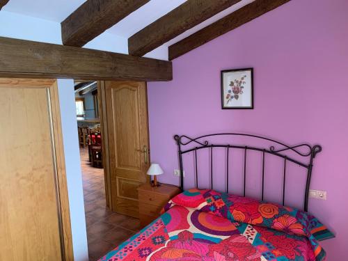 um quarto com paredes cor-de-rosa e uma cama em Apartamento Rural Cardera en la Sierra de Cazorla em Beas de Segura