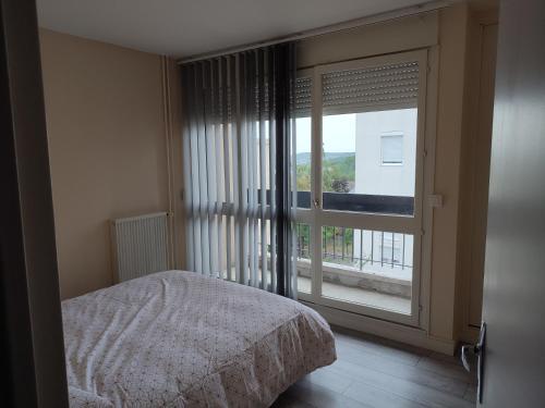 a bedroom with a bed and a large window at Grand et superbe appartement proche Paris in Creil
