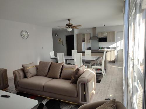 un salon avec un canapé et une salle à manger dans l'établissement Grand et superbe appartement proche Paris, à Creil