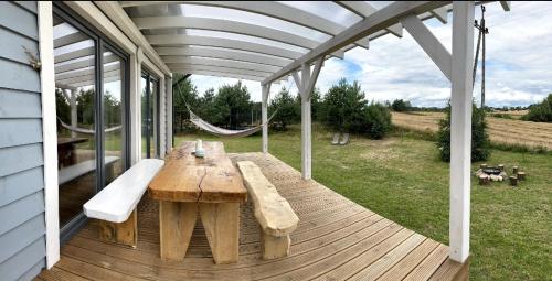 a wooden table with a bench on a deck at Sunset House in Sulęczyno