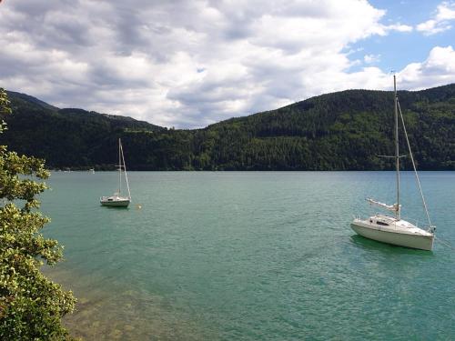 two boats sitting in the water on a lake at DasHausAmSee in Döbriach