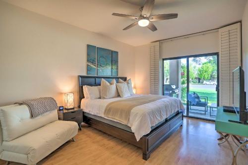 a bedroom with a bed and a couch and a fan at Access to 33 Pools Cathedral City Condo with Patio in Cathedral City