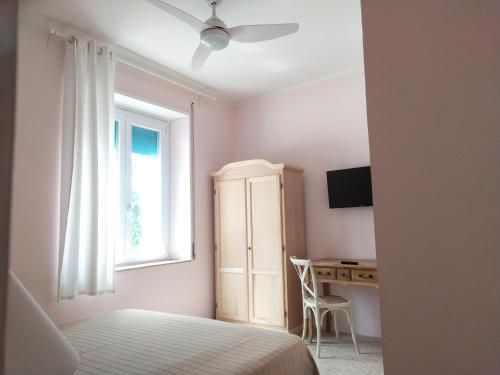 1 dormitorio con cama, ventana y escritorio en Tramonti E Valli, en Calvi dellʼ Umbria