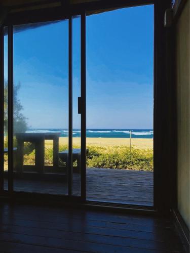 an open door to a patio with a table outside at Underwater Explorer in Ponta do Ouro