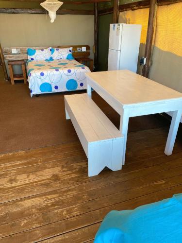 a room with a table and a bed and a refrigerator at Underwater Explorer in Ponta do Ouro