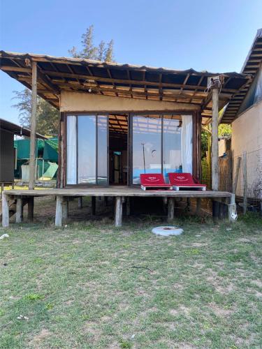 a pavilion with two red chairs on a picnic table at Underwater Explorer in Ponta do Ouro