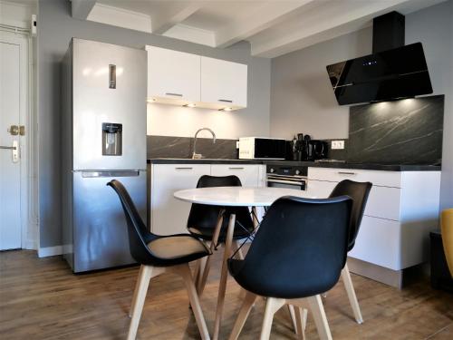 uma cozinha com mesa e cadeiras num quarto em Appartement moderne entièrement rénové em Aurillac