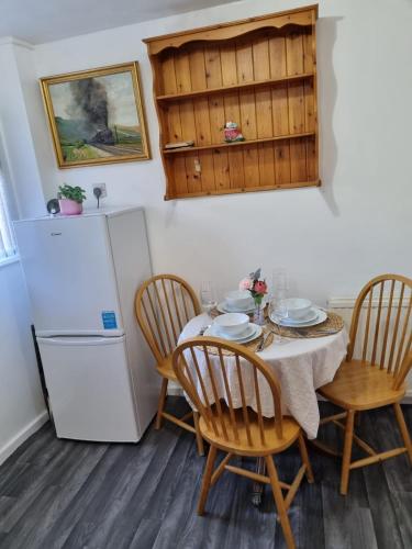 a kitchen with a table and chairs and a refrigerator at Glamorous room with WiFi and Netflix in Leeds