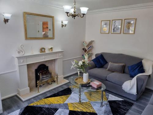 a living room with a couch and a fireplace at Glamorous room with WiFi and Netflix in Leeds