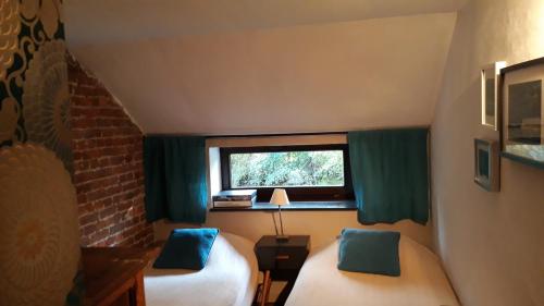 een kleine kamer met 2 bedden en een raam bij La Ferme du Couchant in Beauraing