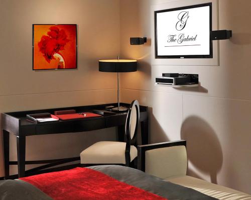 a bedroom with a desk and a bed with a red blanket at Sun City Hotel - The Gabriel in Cairo