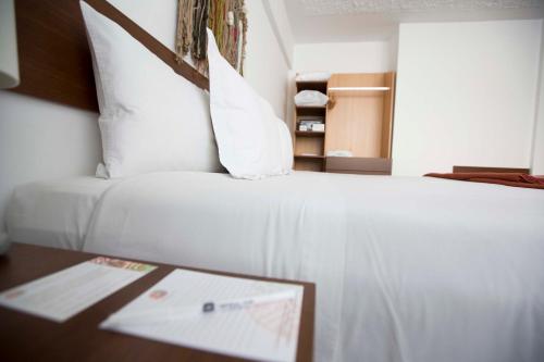 a hotel room with a white bed and a table at Tierra Viva Puno Plaza in Puno