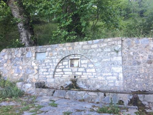 a stone wall with a small window on it at Rapsani Panorama Villa in Rapsáni