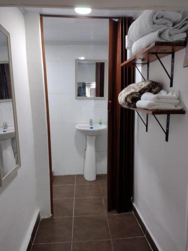 a bathroom with a sink and a toilet and towels at El Hostal By Pochet in San Andrés