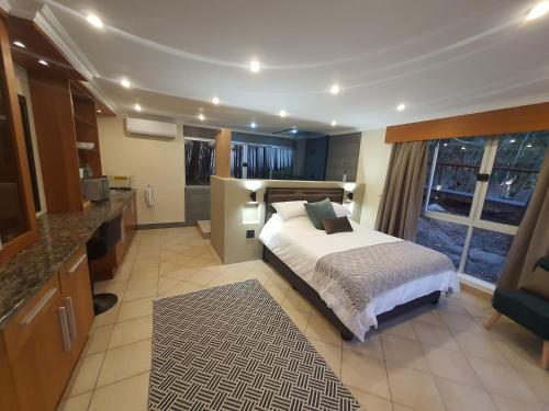 a large bedroom with a bed and a large window at Bikkurim Inn in Nelspruit