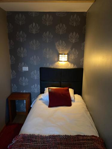 a bedroom with a bed with a red pillow on it at Cabañas El Galo in Panguipulli
