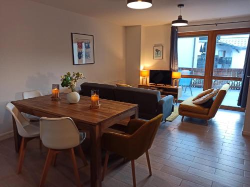 a living room with a wooden table and chairs at Label OR appartement spacieux proximité pistes in Les Deux Alpes